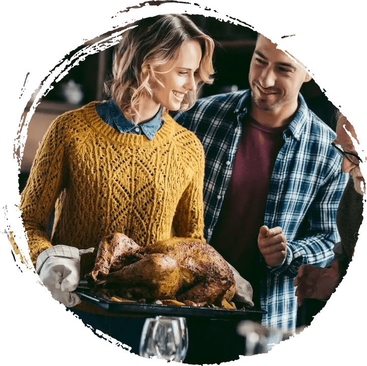 A man and woman standing next to a turkey.
